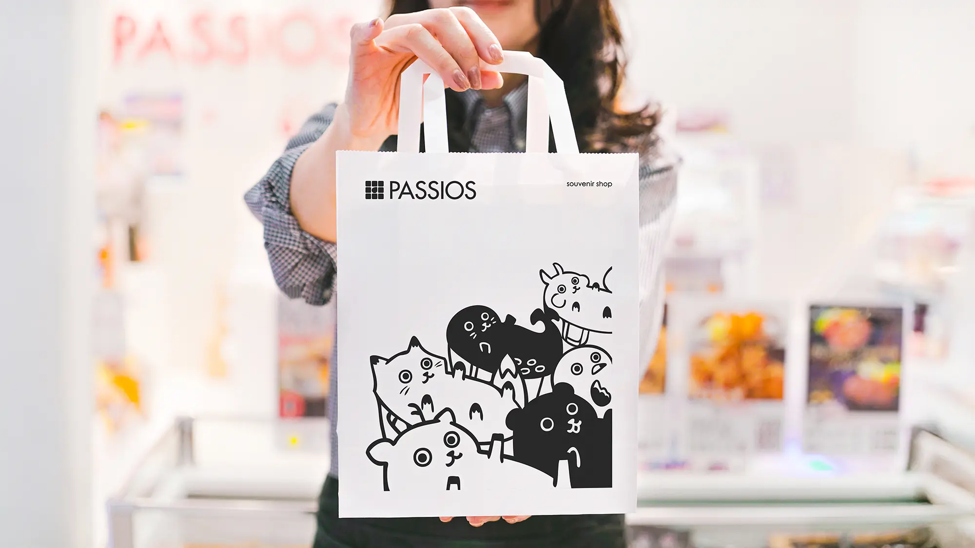 店頭で紙袋を持つ店員